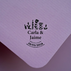 sobre sellado con los nombres de los novios, la fecha y diseño de flores decorativas