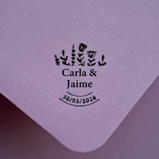 sobre sellado con los nombres de los novios, la fecha y diseño de flores decorativas